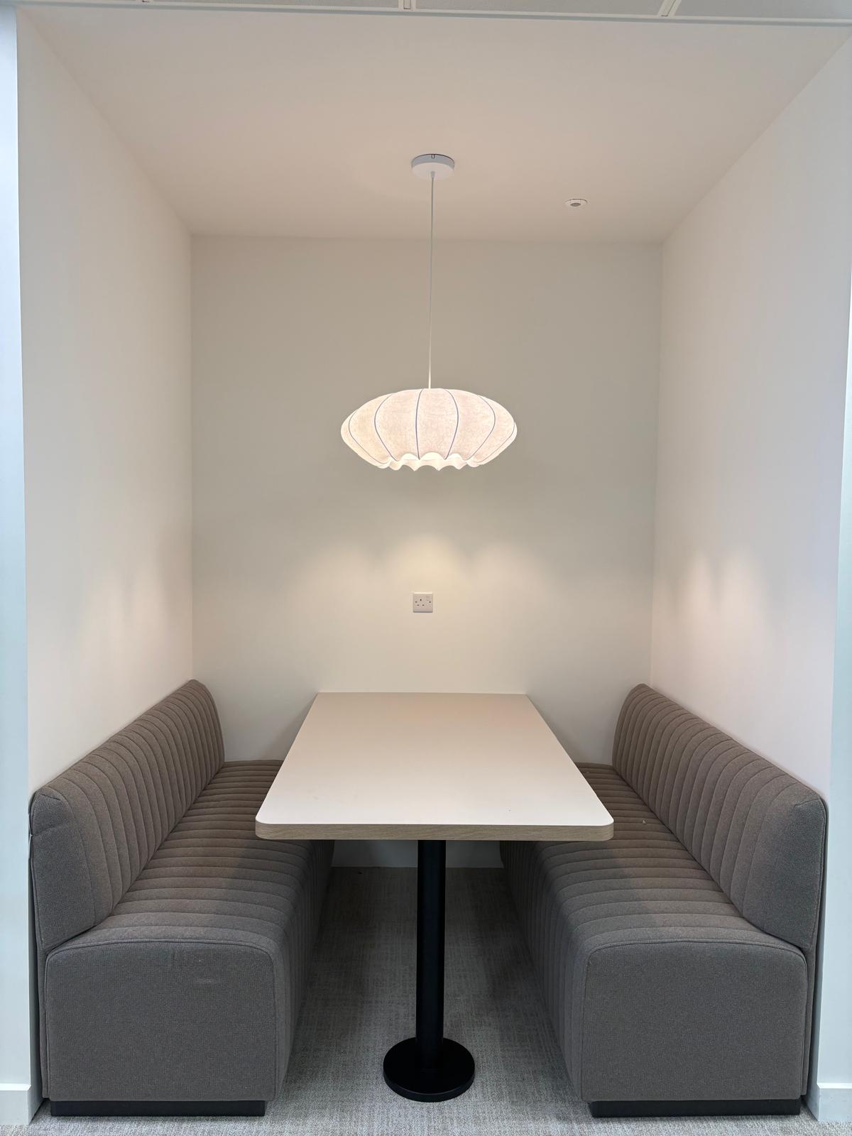 Finished workplace booth with a pendant light and power outlet